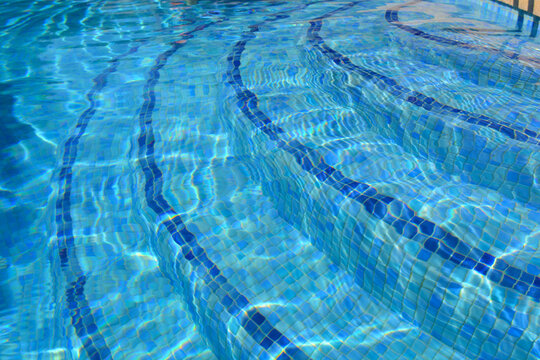 Sparkling water in blue tiled Swimming pool