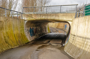 Gouda, The Netherlands,  February 19, 2023: meandering concrete underpass for pedestrians and cyclists under a busy road