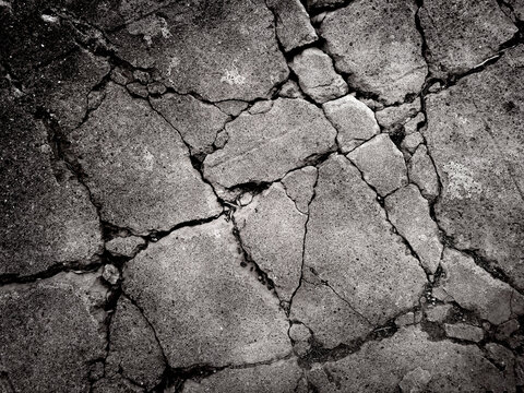 In the eerie black and white landscape, the concrete is riddled with many cracks. Double exposure creative hologram.
