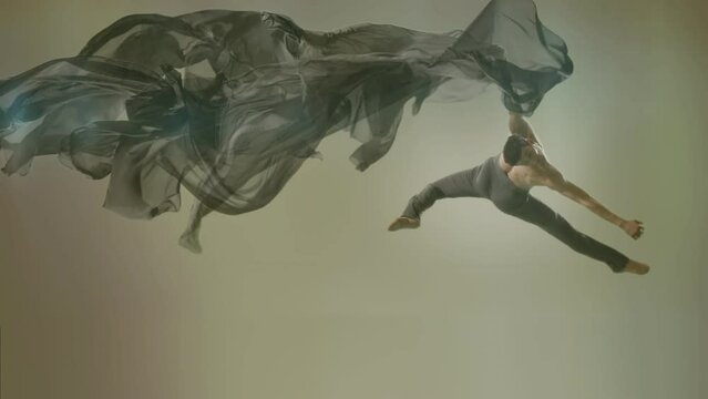 Art dance moves with long fabrics . Few shots of the powerful psychological contemporary ballet dancing movements with large textile materials . People dancing , flying , jumping . Growth of cloth