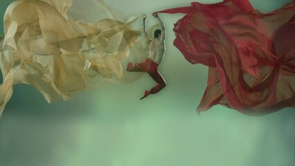 Art dance moves with long fabrics . Few shots of the powerful psychological contemporary ballet dancing movements with large textile materials . People dancing , flying , jumping . Growth of cloth