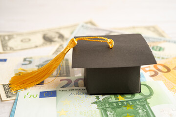 Graduation gap hat on Euro and US dollar banknotes money, Education study fee learning teach concept.