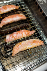 Closeup and crop beef and pork slice grilling on stove. Japanese grilled meat Yakiniku.