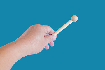 Hand holding a Woodenstick ,drumstick  on background.