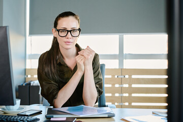 Young confident female boss or administrator of business company in eyeglasses and smart casualwear...