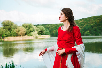Vintage portrait of a beautiful noble lady in a red dress near the river 1