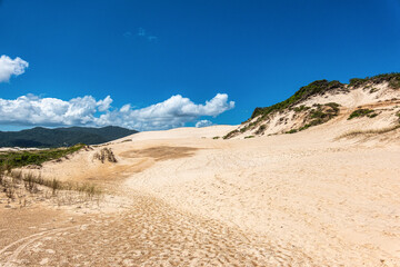 Joaquina beach with stone and dunes in Florianopolis, Santa Catarina, Brasil.