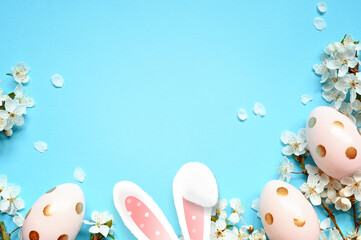 Easter decoration on a blue background. Bunny and eggs. Top view. Copy space.