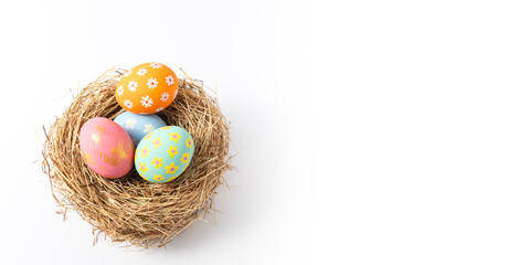 Colorful easter eggs in nest on white copy space background.