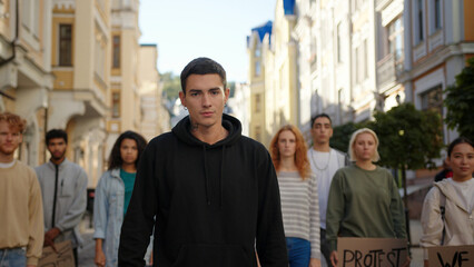 Man activist shows Go poster with multiraciaal people protest activists in background