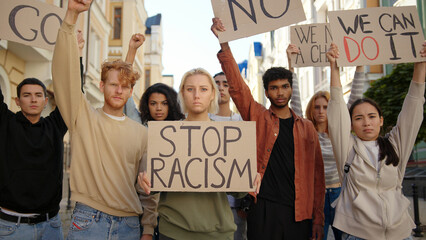 Public demonstration at street against racism with slogans on posters. Multiethnic people protest