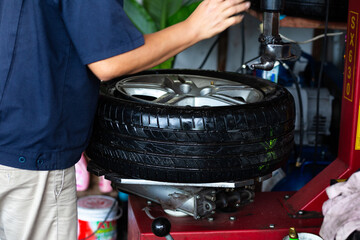 Technical man working replacement car tire shop