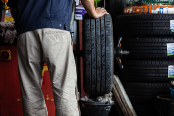 Obraz na płótnie Canvas Technical man working replacement car tire shop
