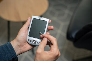Old school PDA device with stylus from early 2000s and millennium 