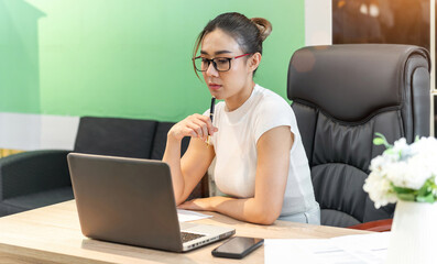 beautiful business asian woman thinking. office person sitting wonder about online meeting plan at workplace. a beautiful female employee sit thinking about group work idea for business team party