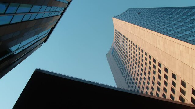 The outside of the university of Leipzig and a skyscraper in Saxony, Germany. The building is a transformed church and showcases modern architecture.  During sunrise golden hour.