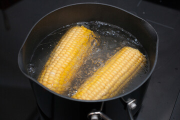 Sweetcorn boiling in a pan on the hob
