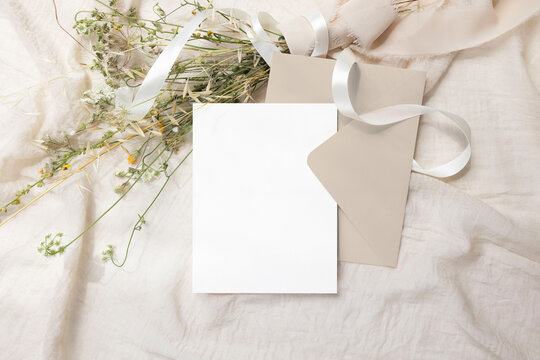 Greeting card mockup with bouquet of wild flowers and envelope