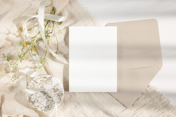 Greeting card mockup with envelope, ribbon  and bouquet of wild flowers 