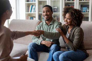 Positive smiling african american couple shaking therapist hand