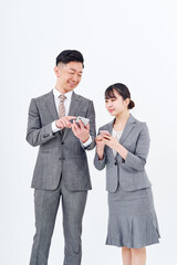 スマートフォンを持つスーツ姿の男女