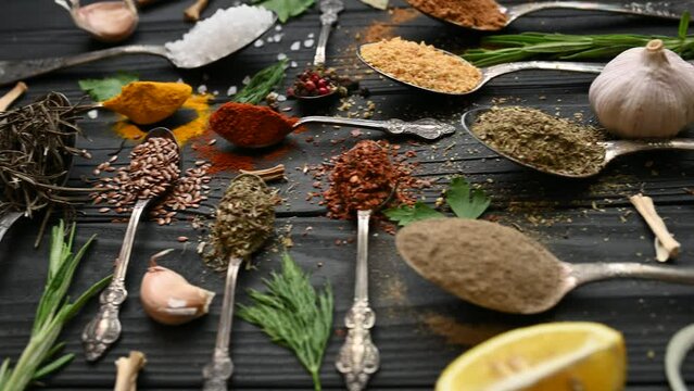 Colorful herbs and spices for cooking. Indian spices. On a black background. Top view