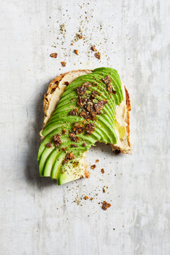 Appetizing toast with avocado and hummus placed on table