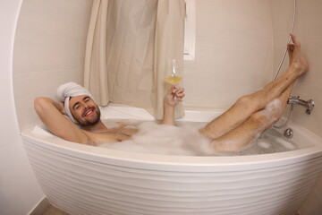 Man drinking wine in the bathtub