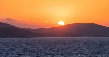Rocky Island on Mediterranean Sea. Rinia near Mikonos, Greece, Europe. Nature Background. Sunrise Sky