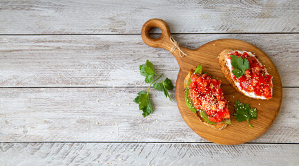 Bruschetta with cottage cheese, avocado, tomatoes, greens, white sesame seeds. Healthy food, rich in healthy fats, fiber, vitamins, antioxidants. Vegetarian food.