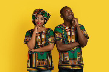 Excited black man and woman in traditional costumes thinking
