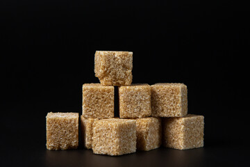 Refined cane sugar on a black background. sugar cubes