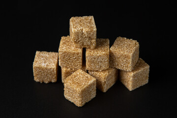 Refined cane sugar on a black background. sugar cubes