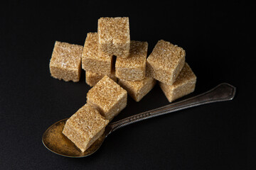 Refined cane sugar on a black background. sugar cubes