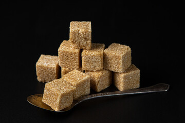 Refined cane sugar on a black background. sugar cubes