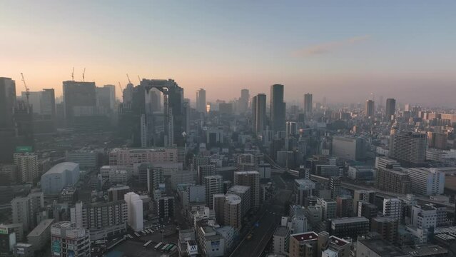 Aerial approach towards high rise office buildings in city at sunrise