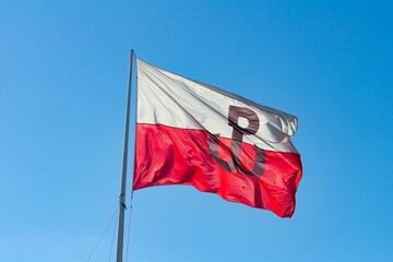 Flag of Polish Underground State (Polskie Panstwo Podziemne and Armia Krajowa) waving in wind in Poland with blue sky - obrazy, fototapety, plakaty