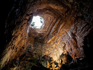 Hole in karst cave Grotte di Castellana, Italy with beuatiful lights