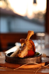 a piece of meat in a plate on a table with blurry background