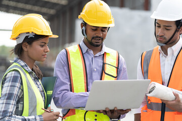 India engineer man holding laptop computer with team engineer at precast site work	