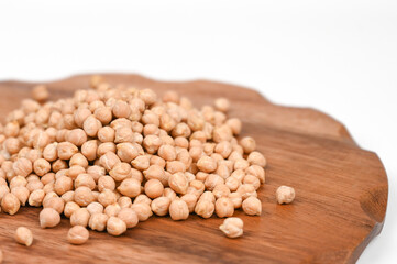 Scattered chickpea in a wooden plate, isolated on white backround