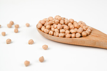 Chickpeas in a wooden spoon islated on white side view