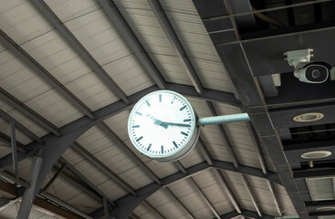 Public clock in sky train station with cctv.