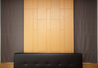 Brown leather headboard decorated with wooden wall and brown curtain.