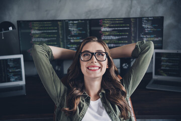 Photo of smiling dreamy lady boss wear eyeglasses hands arms behind head having rest indoors workplace workstation