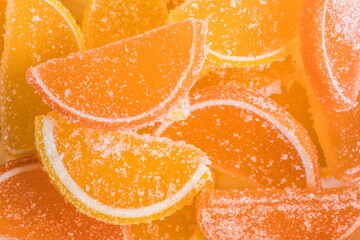 Decorative Background of yellow and orange marmalade candy in shape of citrus fruits wedges. Jelly sweet candies. Food Texture. Beautiful square Wallpaper or Web banner. Top view. Flat lay