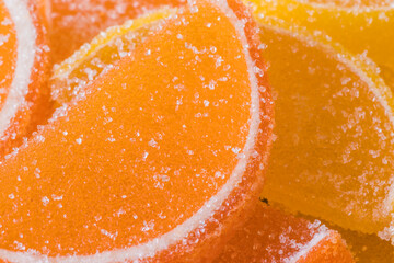 Decorative Background of yellow and orange marmalade candy in shape of citrus fruits wedges. Jelly sweet candies. Food Texture. Beautiful square Wallpaper or Web banner.