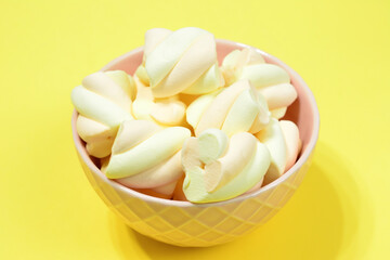 heap of apricot and strawberry marshmallows isolated in pink bowl, close-up