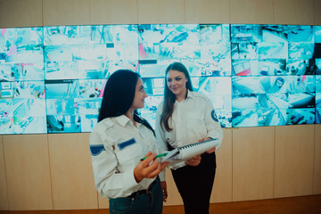 Group portrait of female security operator while working in a data system control room offices...