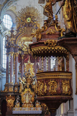 Fototapeta na wymiar Magnificent opulent splendid Bavarian baroque church cathedral basilica interiors with stucco, murals, altar, Pilars, ceiling paintings, gold, wood domes nave